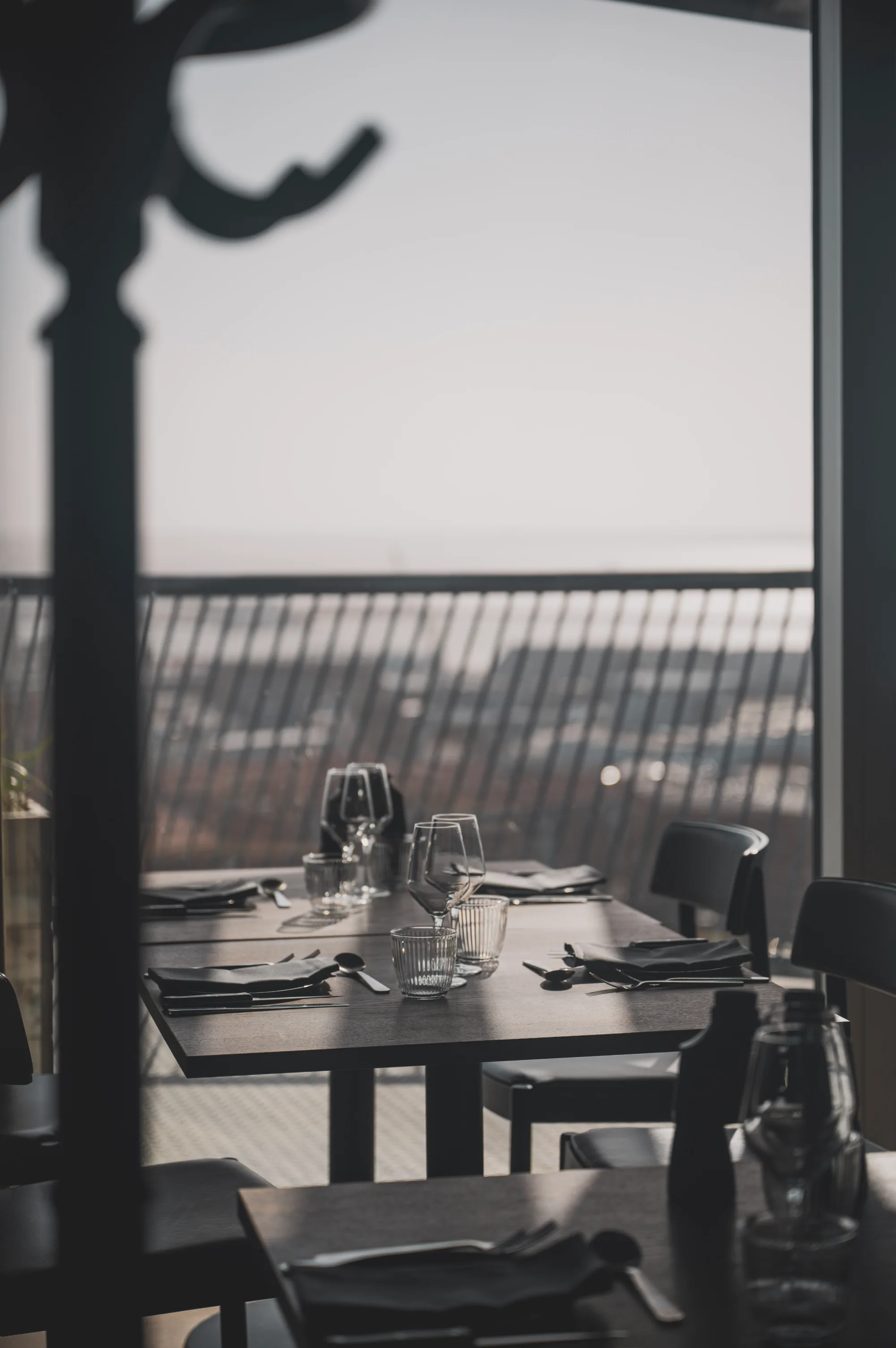 A laid table at dusk with the harbour beyond the glass