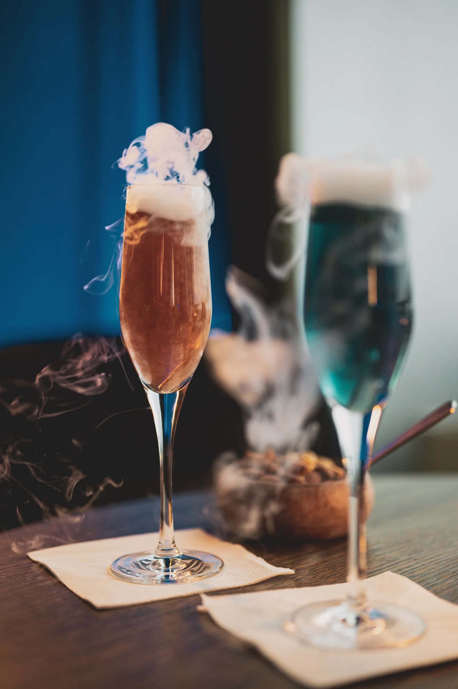 Two cocktails served under a cloud of smoke